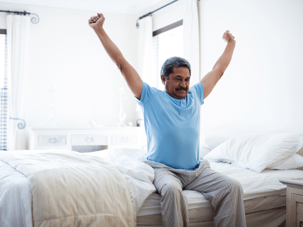 Man stretching his arms in bed